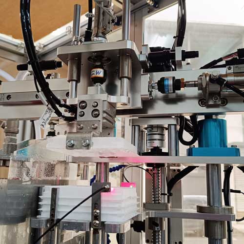 Cylinder-driven infeed/outfeed arm mechanisms for high durability and easy maintenance